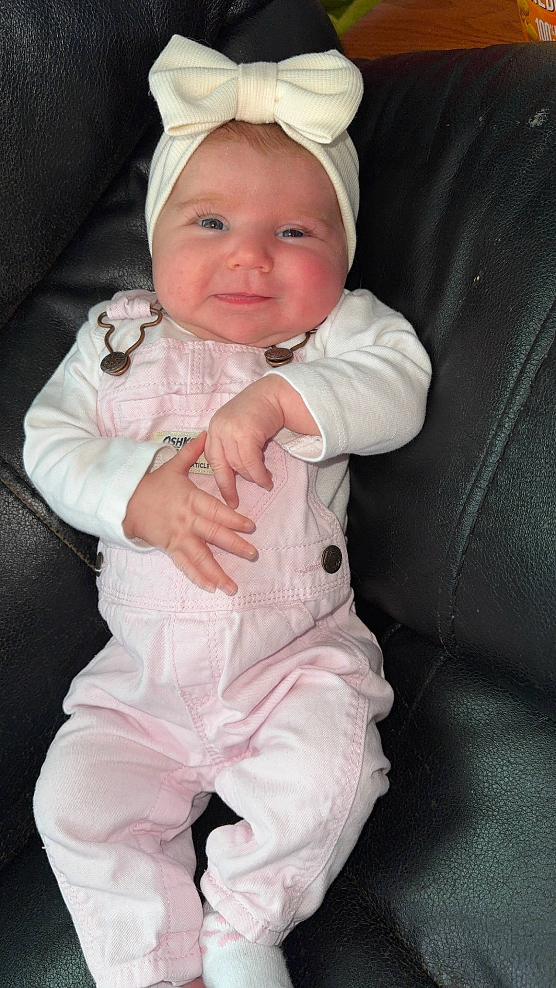 baby, bodypart, bonnet, cap, clothing, coat, couch, cushion, face, finger, furniture, hat, head, homedecor, jacket, newborn, pants, person, photography, portrait