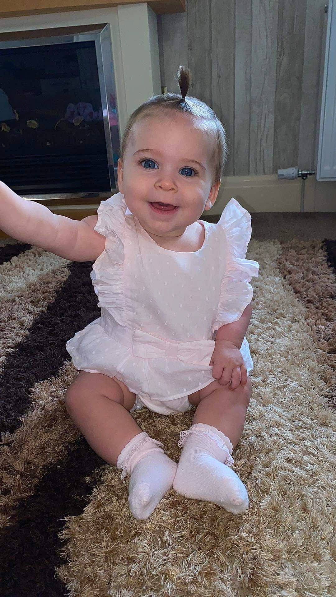 Francesca is registered to the contest to win money with this photo: baby, baby_toddler_clothing, blond, cheek, child, face, flash_photography, flooring, fun, grass, happy, head, human_leg, iris, joy, person, pink, sitting, skin, sleeve