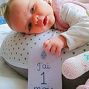 Chloé participe au concours pour gagner de l'argent avec cette photo : baby, infant, cushion, card, hand, knitted_toy, blanket, face, portrait, lying_down, star_pattern, clothing, indoor, cute, child, newborn, resting, soft_toy, sleepy, pink