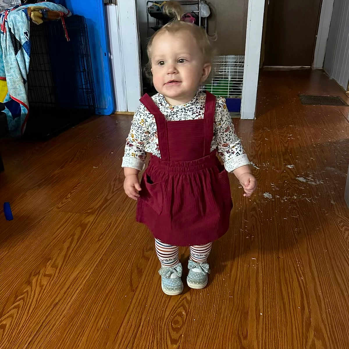 Marcie is registered to the contest to win money with this photo: baby, clothing, door, dress, face, footwear, hardwood, head, indoors, interiordesign, jeans, pants, person, photography, portrait, shoe, sitting, stainedwood, standing, wood