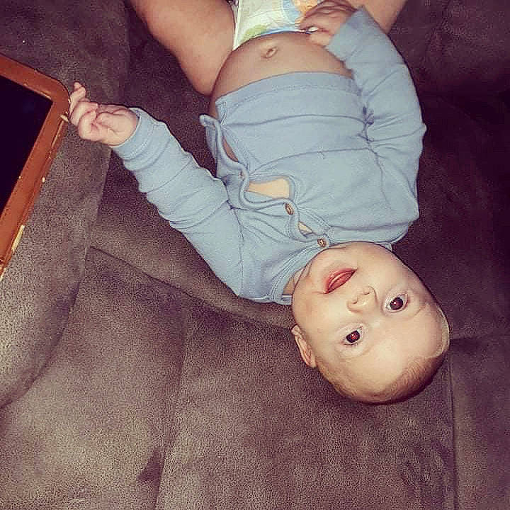 Nathan is registered to the contest to win money with this photo: arm, baby, baby_toddler_clothing, comfort, eye, facial_expression, gesture, hand, head, human, human_body, joint, leg, mammal, mouth, nose, person, skin, sleeve, textile