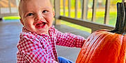 Austin is registered to the contest to win money with this photo: baby, blue_jeans, cheerful, child, cute, daylight, face, fall, hands, happy, infant, nature, outdoor, porch, pumpkin, red_checkered_shirt, seasonal, sitting, smiling, wooden_railings