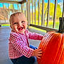 baby, child, pumpkin, porch, smiling, happy, red_checkered_shirt, blue_jeans, outdoor, daylight, face, hands, sitting, wooden_railings, fall, seasonal, cute, cheerful, infant, nature