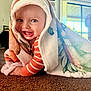 Austin is registered to the contest to win money with this photo: baby, blanket, carpet, child, crawling, face, happy, indoors, infant, light, looking_at_camera, orange_stripes, person, portrait, smile, soft_texture, toddler, window, wrapped, young_child