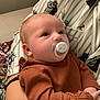 baby, pacifier, infant, child, person, clothing, patterned_shirt, arm, holding, indoor, comfort, cute, closeup, face, young, warm_clothing, striped_shirt, sleepy, relaxed, skin