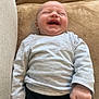 Anaé a rejoint le concours — aidez-le/la à gagner de superbes lots ! baby, laughing, smiling, infant, child, clothing, long_sleeve_shirt, pants, couch, furniture, soft, beige, happy, portrait, indoor, person, cute, relaxed, small_hands, baby_clothes