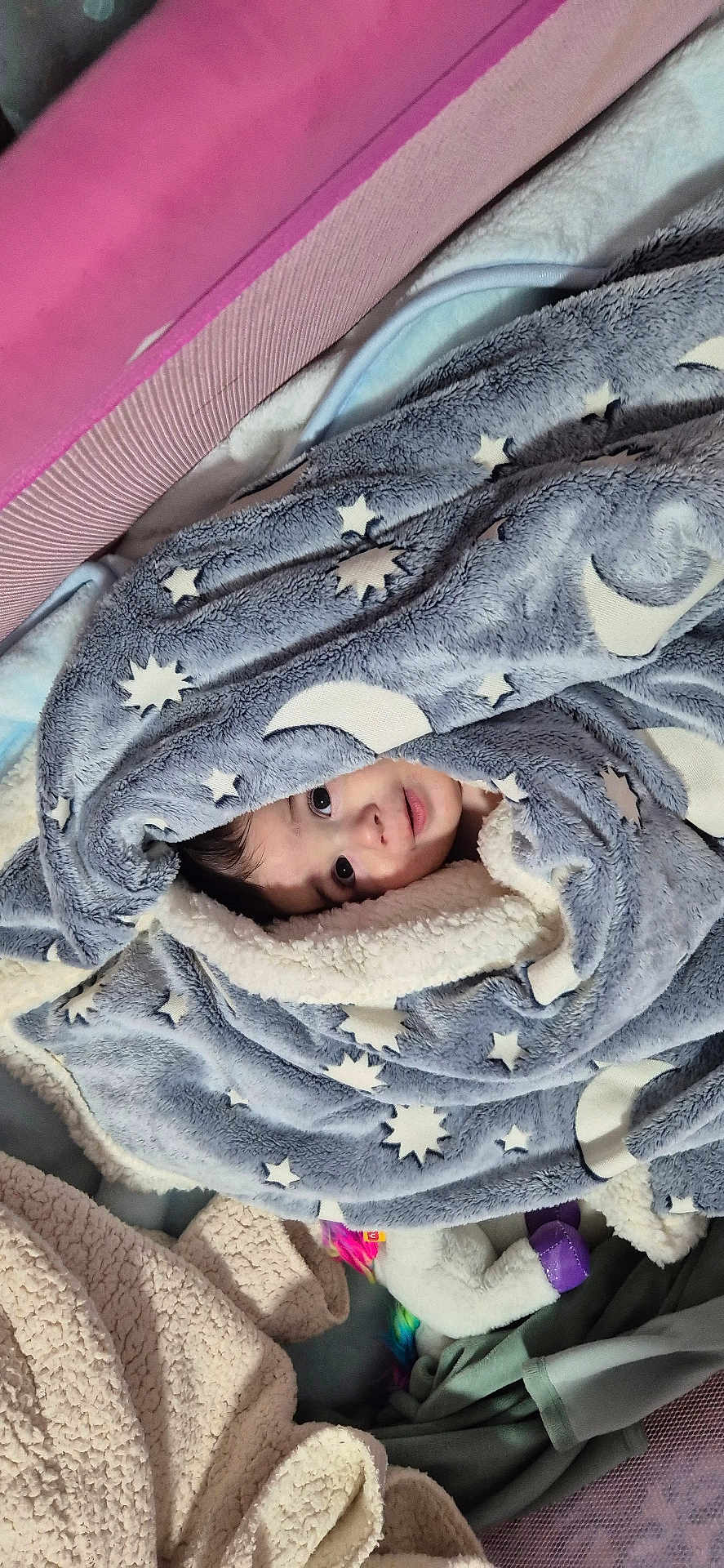 Marcio participe au concours pour gagner de l'argent avec cette photo : baby, blanket, child, face, cozy, indoor, soft, toy, unicorn, fabric, pattern, moon, star, comfort, cute, warm, wrapped, infant, smiling, lying_down