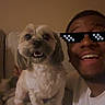 Buchanan is registered to the contest to win money with this photo: dog, person, couch, indoor, smile, happy, pet, friendship, sitting, fur, pixelated_sunglasses, casual, home, light_brown, short_hair, white_tshirt, companion, cute, relaxed, portrait