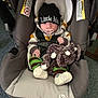 baby, car_seat, pacifier, plush_toy, elephant_toy, hat, beanie, striped_clothing, hoodie, infant, child, indoor, carpet, seat_belt, cute, cozy, soft_toy, child_in_seat, sitting, young_child