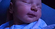 Gideon is registered to the contest to win money with this photo: newborn, baby, sleeping, blue_light, blanket, infant, swaddled, peaceful, soft, closeup, portrait, cozy, child, young, calm, indoors, cute, face, resting, wearing