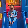 Joslynn is registered to the contest to win money with this photo: child, toddler, slide, playground, blue_slide, colorful, outdoor, sunlight, clothing, hair_accessories, expression, sitting, play, fun, daylight, person, casual_wear, footwear_barefoot, plastic_play_equipment, young_child
