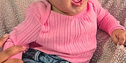 Joslynn joined the competition — help win amazing prizes! baby, child, pink_sweater, ripped_jeans, braided_hair, bead, blanket, hand, smiling, happy, sitting, indoor, cute, portrait, denim, clothing, infant, young_child, emotion, texture