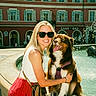 Uppa a rejoint le concours — aidez-le/la à gagner de superbes lots ! blonde, building, casual_clothing, city, daylight, dog, fountain, friendship, happy, leisure, outdoor, pet, red_building, smiling, summer, sunglasses, urban, vacation, water, woman