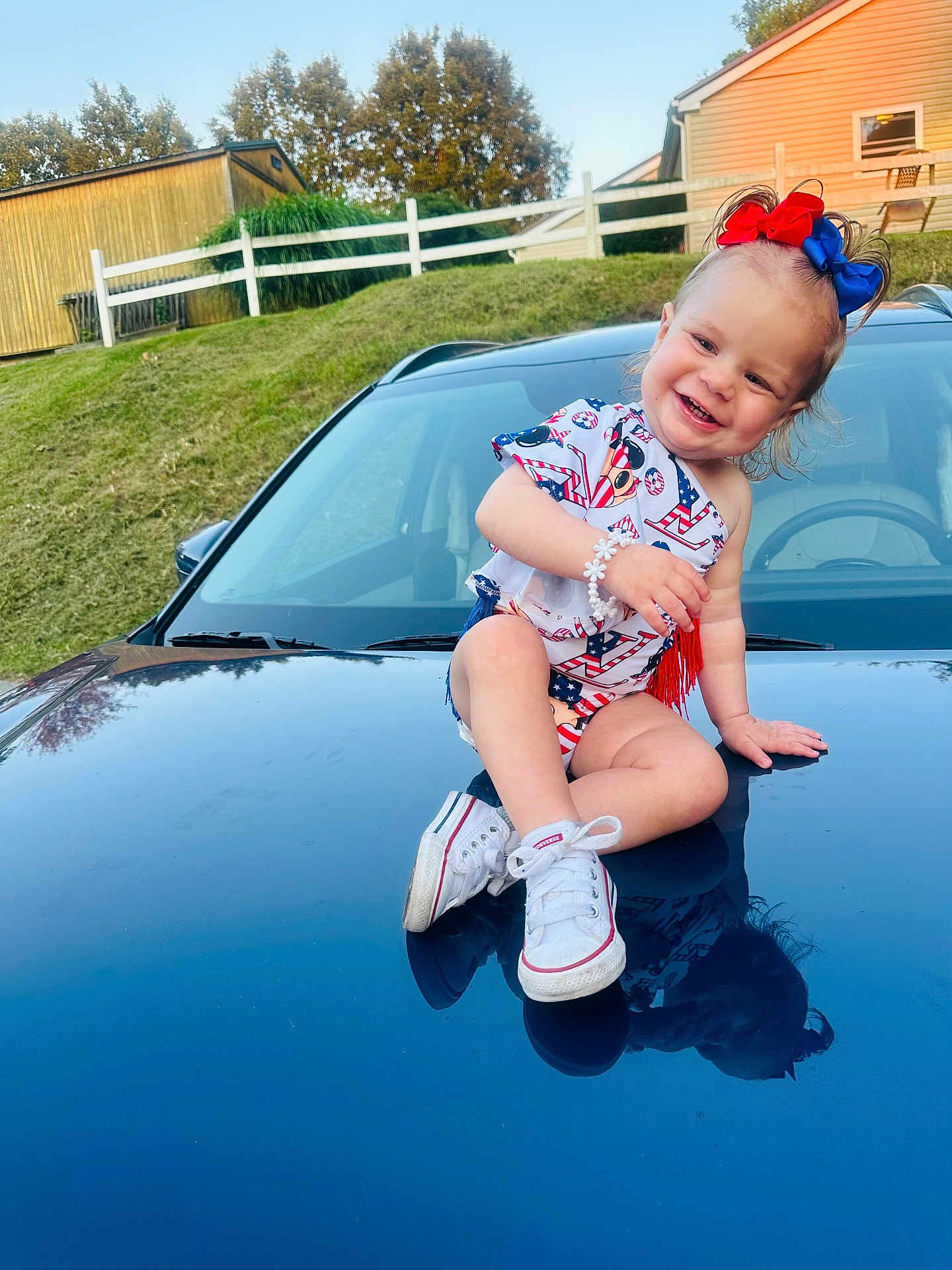 Allison joined the competition — help win amazing prizes! toddler, child, smiling, sitting, car, reflection, shoes, outdoor, grass, house, hair_bow, bracelet, happy, clothing, sidewalk, daylight, nature, portrait, cute, casual