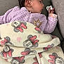 baby, sleeping, blanket, minnie_mouse, purple_jacket, couch, cozy, child, face, hand, soft_fabric, indoor, resting, cute, comfort, warm, young_child, peaceful, nap, infant