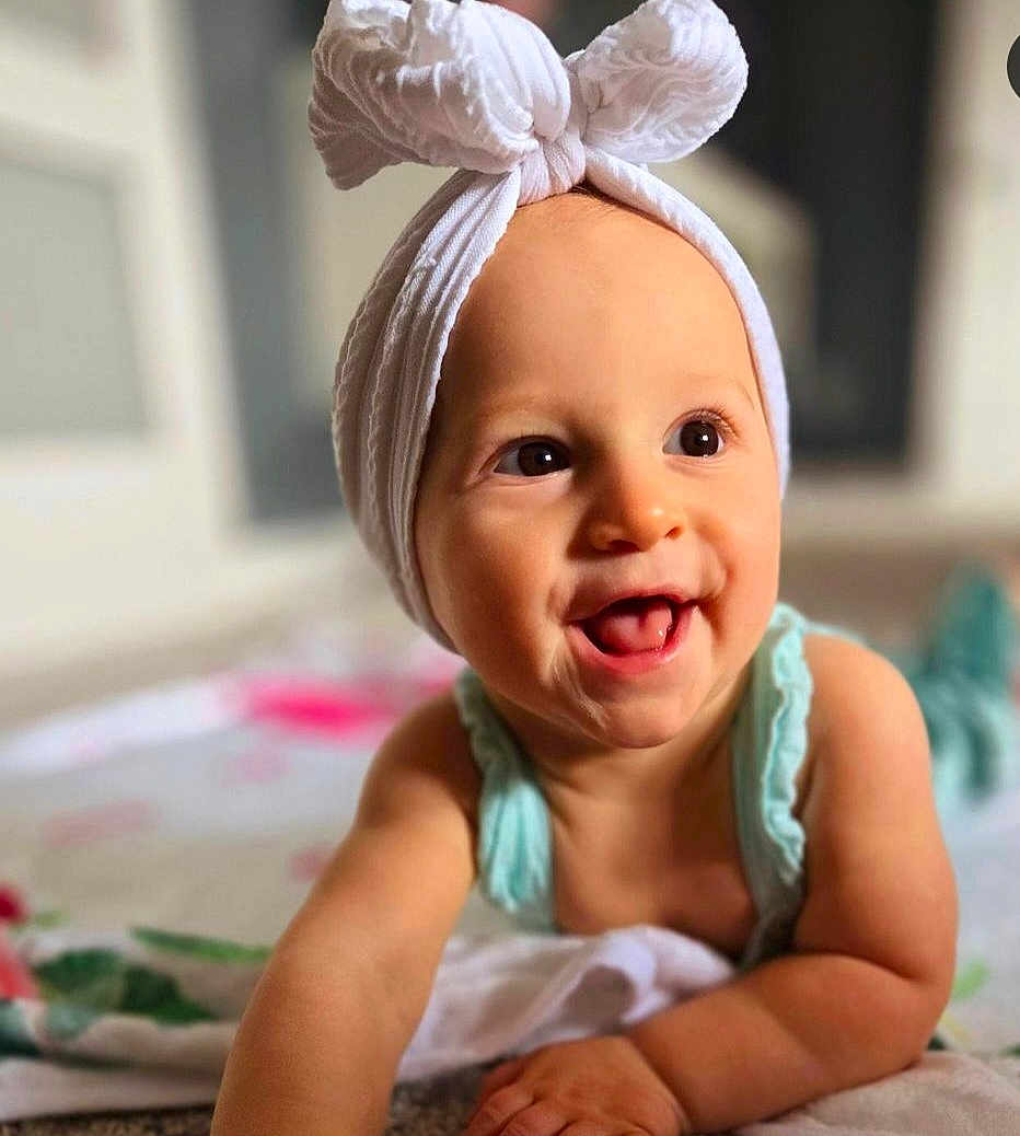 Sophia is registered to the contest to win money with this photo: accessories, baby, babylaughing, clothing, face, happy, head, headband, person, photography, portrait, scarf, smile