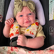 Makenzly Grace is registered to the contest to win money with this photo: baby, blanket, blue_eyes, bow, car_seat, child, clothing, cute, floral_pattern, hands, headband, indoors, infant, person, photography, portrait, rainbow_pattern, safety, seatbelt, smiling
