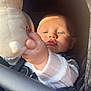 baby, child, plush_toy, hand, face, blue_eyes, sunlight, stroller, clothing, white_sleeve, soft_toy, infant, portrait, cute, close_up, indoor, seat_belt, zipper, fabric, curious
