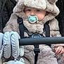 Louie is registered to the contest to win money with this photo: baby, pacifier, stroller, plush, toy, child, hood, fur, cute, infant, warm_clothing, seatbelt, hand, ears, face, blue_eyes, striped, gray, comfort, soft