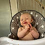 Louie is registered to the contest to win money with this photo: baby, high_chair, food, crumbs, smile, happy, indoor, child, star_pattern, face, hands, eating, messy, furniture, person, skin, head, infant, seat, tongue