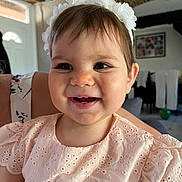 Aerys participe au concours pour gagner de l'argent avec cette photo : baby, cheerful, child, closeup, clothing, cute, eyelet_fabric, face, happy, headband, home, indoor, infant, natural_light, person, pink_dress, portrait, smiling, toddler, white_flower