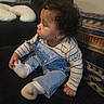 baby, blanket, casual_clothing, child, couch, cozy, curious, curly_hair, cute, denim_overalls, foot, furniture, hand, home, indoor, seated, side_profile, socks, striped_shirt, toddler