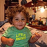 Arion joined the competition — help win amazing prizes! toddler, child, curly_hair, green_shirt, sitting, bed, indoor, smile, face, person, clothing, furniture, mirror, books, hat, room, cabinet, toy, head, portrait
