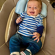 Elio a rejoint le concours — aidez-le/la à gagner de superbes lots ! baby, child, smiling, striped_shirt, denim_pants, sneakers, baby_chair, cushion, happy, indoor, person, infant, cute, seated, footwear, clothing, head, face, young_child, joyful