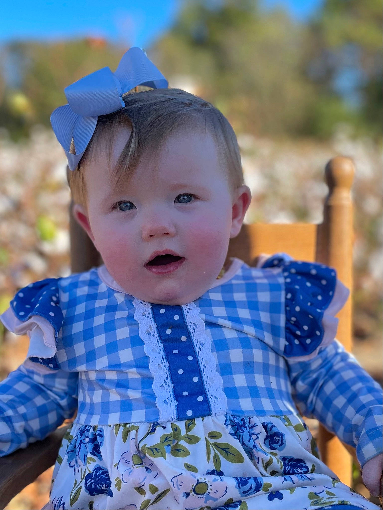 Eden is registered to the contest to win money with this photo: azure, baby_toddler_clothing, eye, face, facial_expression, grass, happy, iris, light, lip, pattern, person, photograph, plaid, skin, sleeve, smile, summer, tartan, textile