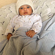 Muhammad is registered to the contest to win money with this photo: animal_print, baby, bed, blanket, child, clothing, cozy, cute, face, hand, hat, indoor, infant, knit_hat, pillow, portrait, soft, surprised, swaddled, wide_eyes