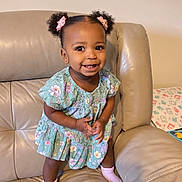 Rose joined the competition — help win amazing prizes! toddler, child, smiling, pigtails, pink_bows, floral_dress, pink_socks, leather_couch, indoor, happy, cute, person, portrait, standing, home, furniture, baby, skin, face, young_child