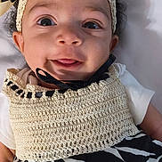 Anastasia joined the competition — help win amazing prizes! baby, infant, child, smile, tongue, headband, bow, curly_hair, eyes, face, cheeks, crochet_top, zebra_print, dress, lying_down, blanket, portrait, close_up, adorable, person