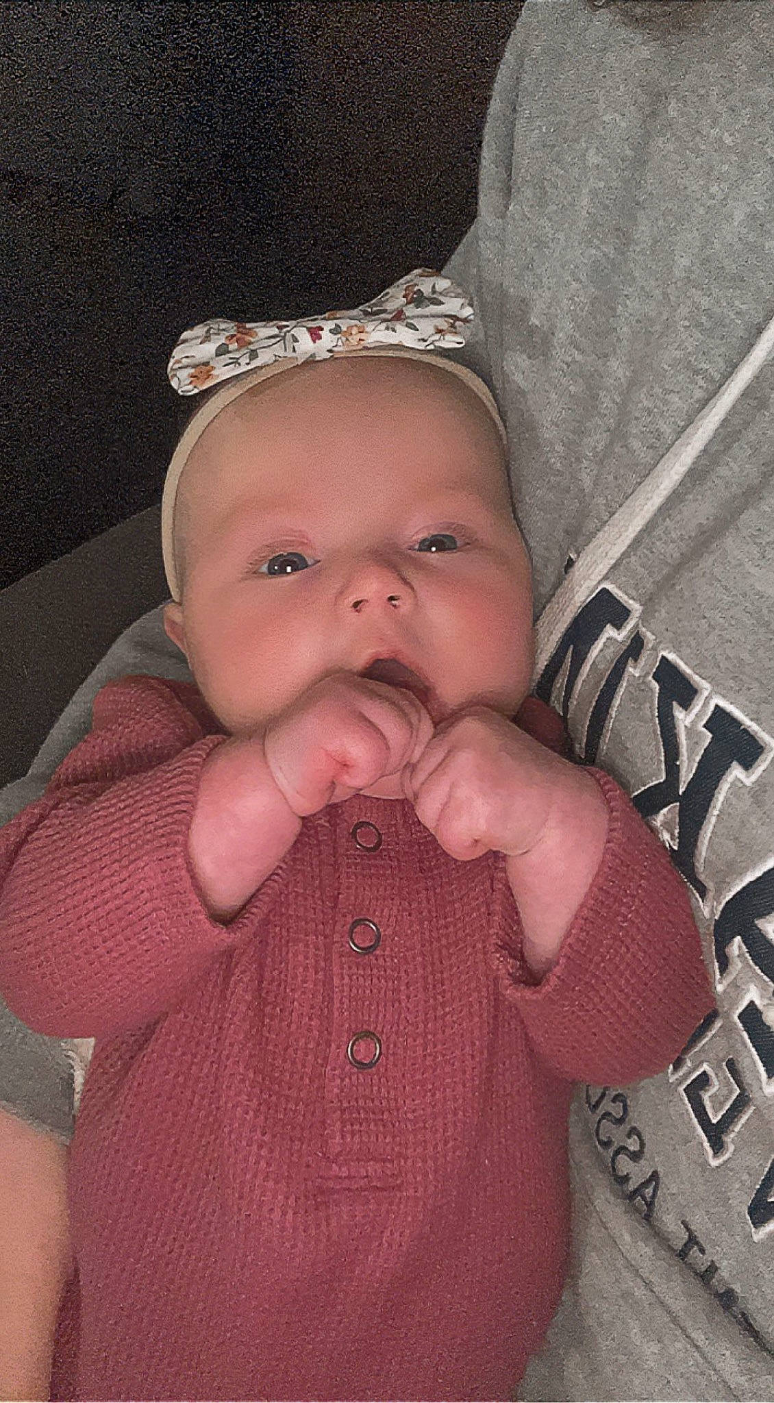 Everly is registered to the contest to win money with this photo: arm, baby, baby_toddler_clothing, cap, cheek, ear, eye, eyelash, face, gesture, hand, happy, human_body, lip, mouth, nose, person, skin, sleeve, thumb