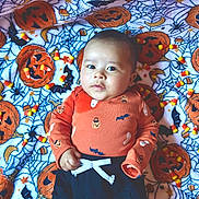 Zion joined the competition — help win amazing prizes! baby, black_pants, blanket, candy_corn, child, costume, cute, decorative, festive, halloween, holiday, indoors, infant, jack_o_lantern, lying_down, orange_clothing, portrait, soft_texture, spider_web, white_tie