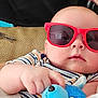 baby, sunglasses, plush_toy, infant, striped_clothing, hand, face, cute, child, toy, red, blue, soft_toy, comfort, relaxing, indoor, person, portrait, casual, close_up
