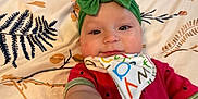 Maaliyah joined the competition — help win amazing prizes! baby, child, headband, green_bow, bib, colorful, floral_blanket, reaching_hand, cute, infant, lying_down, portrait, face, smile, indoors, person, clothing, closeup, baby_girl, soft_lighting