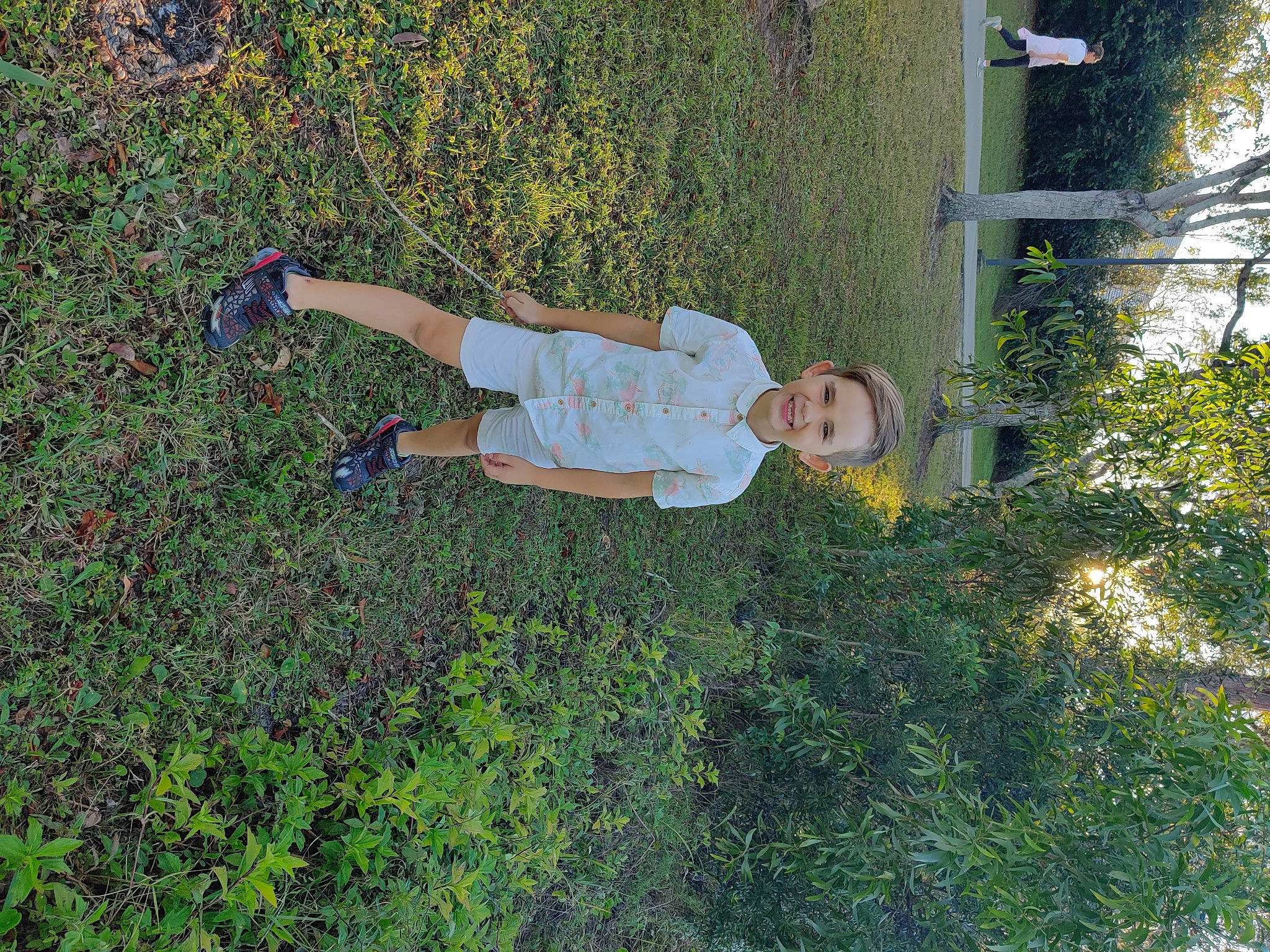 Killian is registered to the contest to win money with this photo: baby, baby_toddler_clothing, fun, grass, grassland, groundcover, joy, leaf, leisure, people_in_nature, person, plant, shadow, shrub, toddler, tree