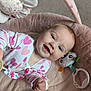 Ellie joined the competition — help win amazing prizes! baby, child, smiling, onesie, heart_pattern, toy, stuffed_flower, pink_cushion, soft_texture, hand, face, blue_eyes, light_hair, indoor, carpet, playtime, cute, infant, closeup, portrait