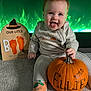 baby, carpet, celebration, child, cute, decor, festive, footprints, green_light, halloween, holiday, infant, orange, pajamas, playful, pumpkin, sign, sitting, smile, tongue_out