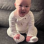 baby, child, infant, smiling, happy, sitting, pajamas, white_clothing, couch, furniture, indoors, cute, young_child, face, hands, feet, cozy, portrait, expression, home