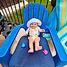 baby, blue_chair, child, colorful, cute, footwear, furniture, garden, grass, happy, hat, infant, outdoor, patio, playful, sitting, smile, summer, sun_hat, toy