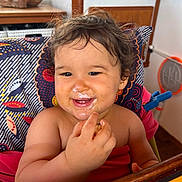 Hëloyse a rejoint le concours — aidez-le/la à gagner de superbes lots ! toddler, child, smiling, messy_face, curly_hair, high_chair, food, indoor, happy, cute, person, baby, eating, colorful, furniture, hand, table, closeup, portrait, skin