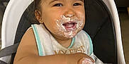 Hëloyse a rejoint le concours — aidez-le/la à gagner de superbes lots ! baby, high_chair, yogurt, messy_face, smiling, child, food, feeding, happy, indoor, face, sitting, bib, person, furniture, cream, cute, young_child, table, eating