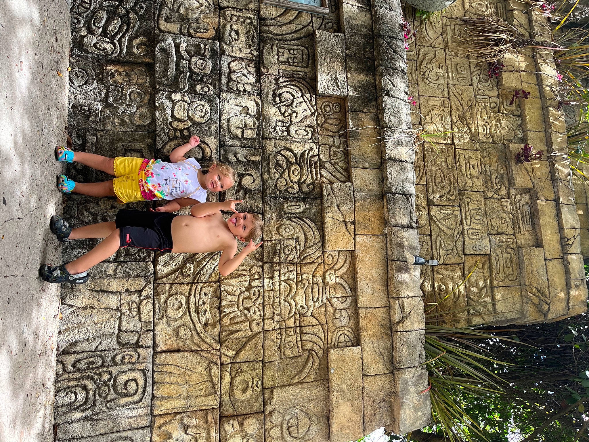 Quinton is registered to the contest to win money with this photo: adventure, ancient_history, archaeological_site, art, facade, font, historic_site, history, human_leg, leisure, person, plant, rock, shorts, sunglasses, t_shirt, thigh, travel, tree, visual_arts