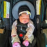 newborn, baby, infant, sleeping, car_seat, harness, bow, headband, pink_socks, onesie, clothing, portrait, indoors, child, face, closed_eyes, seated, safety_buckle, stroller, cozy