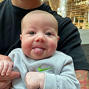 Presley is registered to the contest to win money with this photo: baby, child, tongue, smile, face, person, hand, holding, tattoo, sweatshirt, nike, adult, beard, indoor, window, light, casual_clothing, closeup, cute, playful