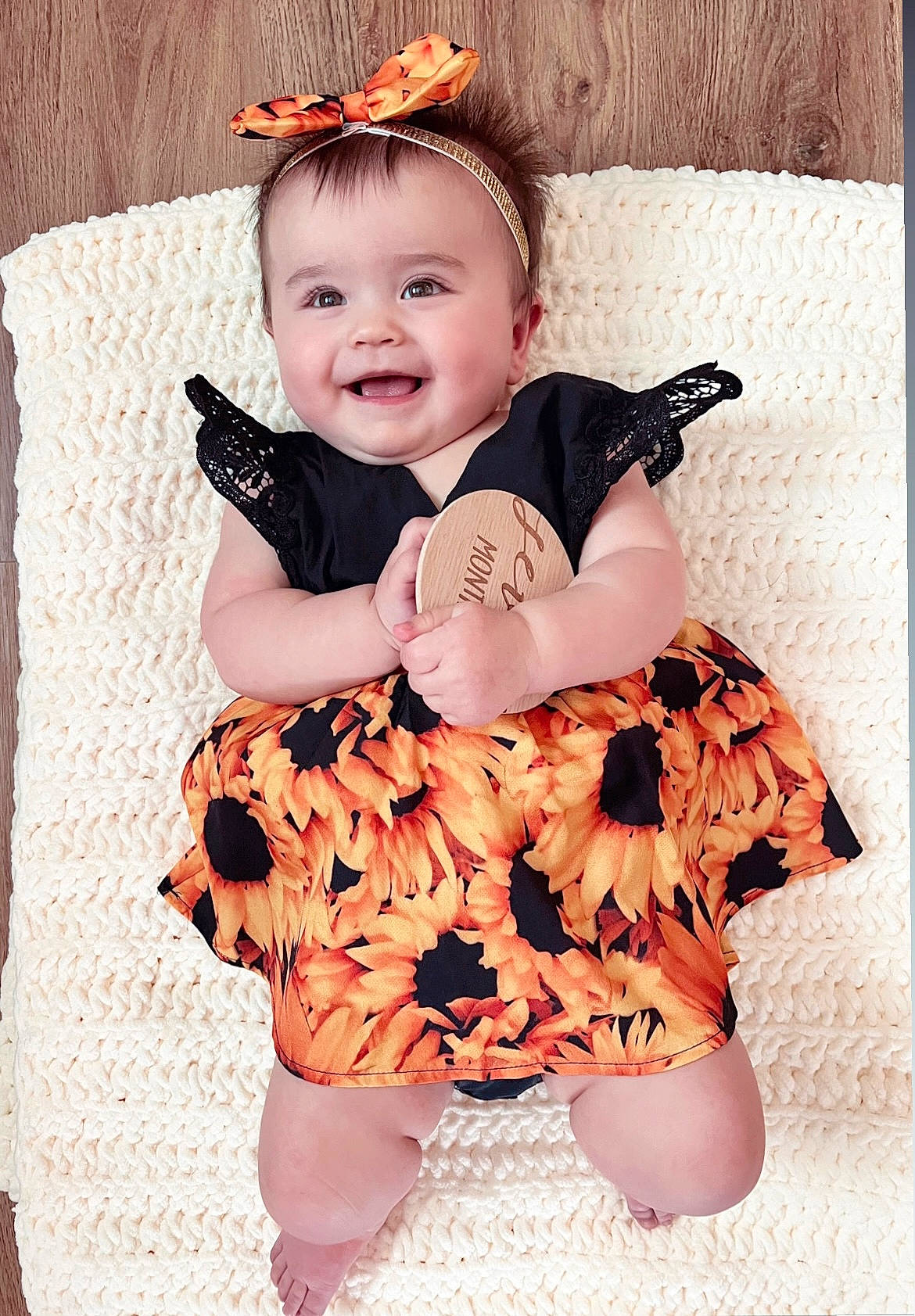 Kora is registered to the contest to win money with this photo: baby, baby_toddler_clothing, child, comfort, eye, face, happy, head, headgear, joy, orange, pattern, person, pink, sitting, skin, sleeve, smile, textile, thigh