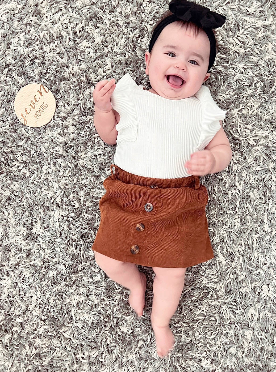 Kora joined the competition — help win amazing prizes! baby_toddler_clothing, clothing, collar, dress, face, facial_expression, gesture, grass, hand, happy, outerwear, people_in_nature, person, photograph, skin, sleeve, smile, standing, textile, toddler