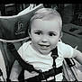 toddler, child, smile, face, stroller, seatbelt, indoors, black_and_white, happy, baby, person, hair, clothing, sitting, seat, straps, toy, expression, young_child, portrait