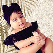 Milenna is registered to the contest to win money with this photo: baby, child, black_clothing, headband, foot, hand, skin, portrait, cute, infant, toddler, smile, playful, sitting, closeup, person, indoors, soft_light, background, fashion